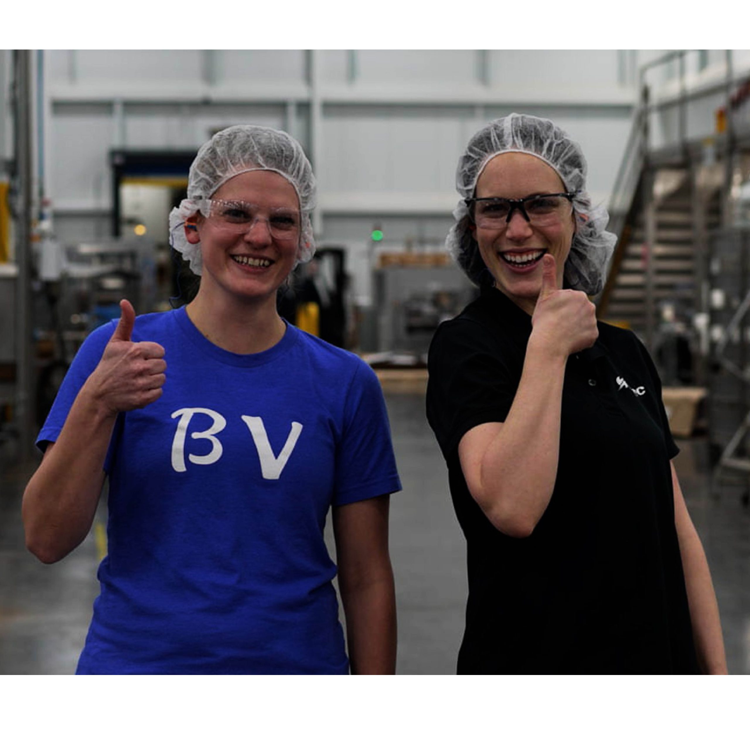 two cqc workers giving a thumbs up in the manufacturing plant